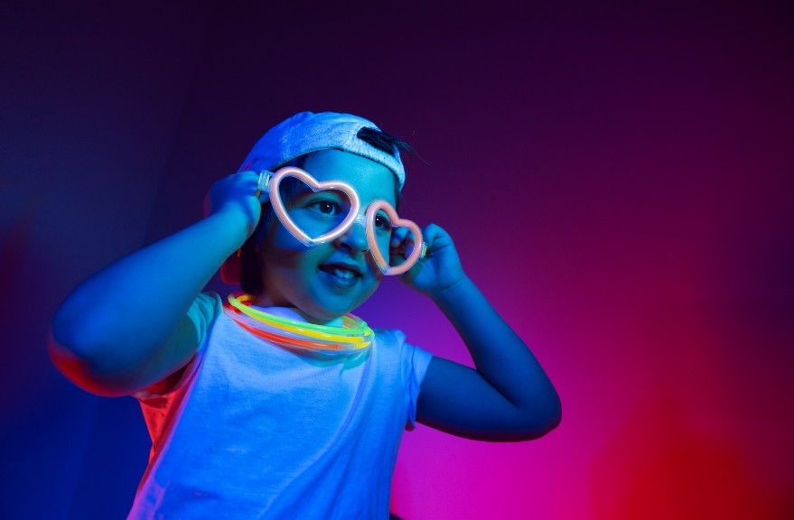 young boy wearing glowing necklaces and glasses